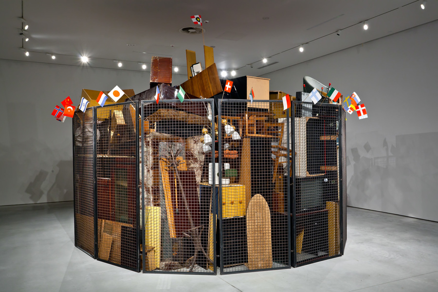 Jarosław Kozłowski, //Zjednoczony świat – wersja totalitarna//, 2000, instalacja / stalowe kraty, meble, akcesoria AGD, flagi, Ø około 5 m, Kolekcja MOCAK-u, fot. R. Sosin